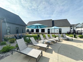 A patio with chairs and umbrellas in front of a building